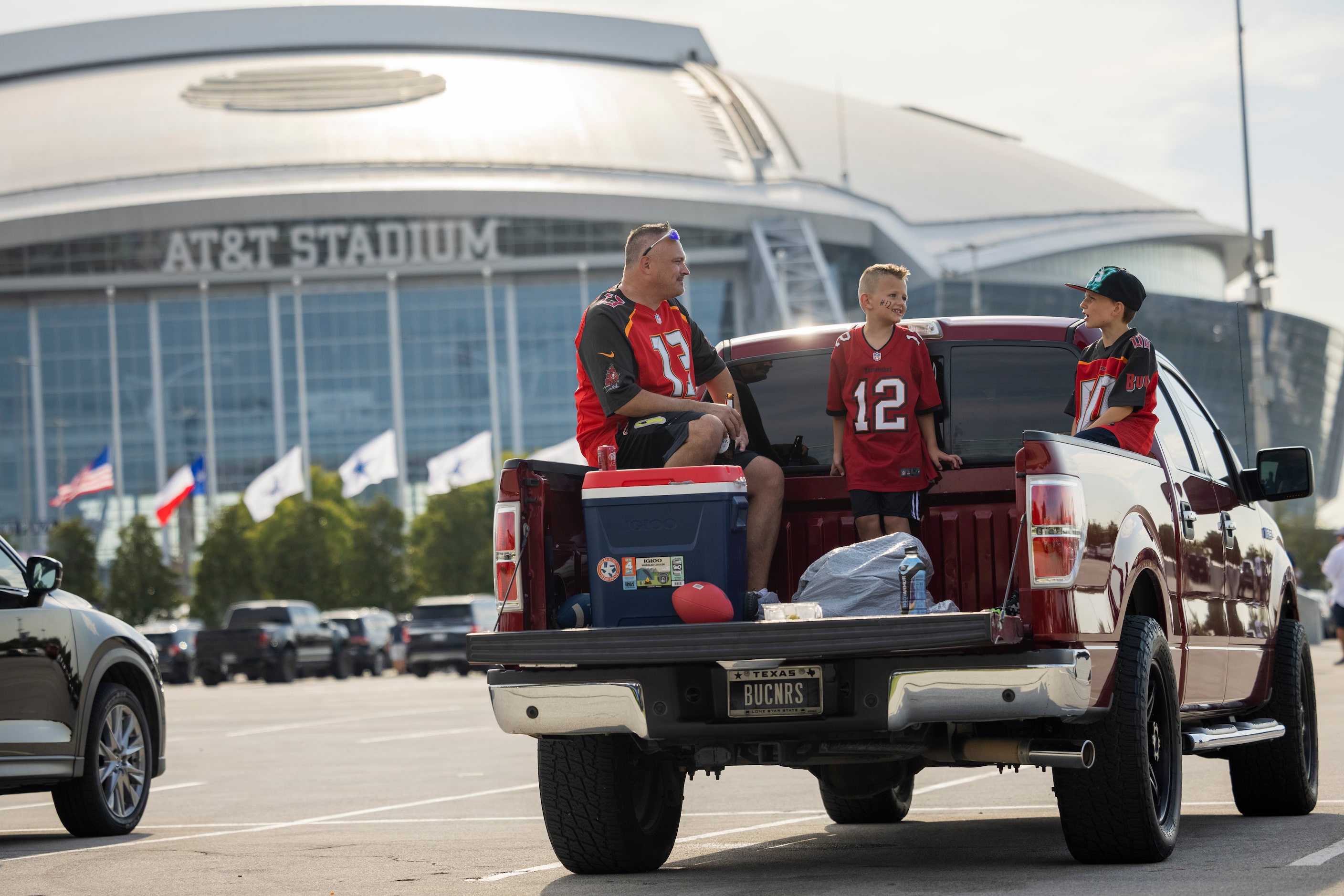 (From left) Aaron Meehan of Dallas enjoys a chat on his tailgate with his sons Decklyn...