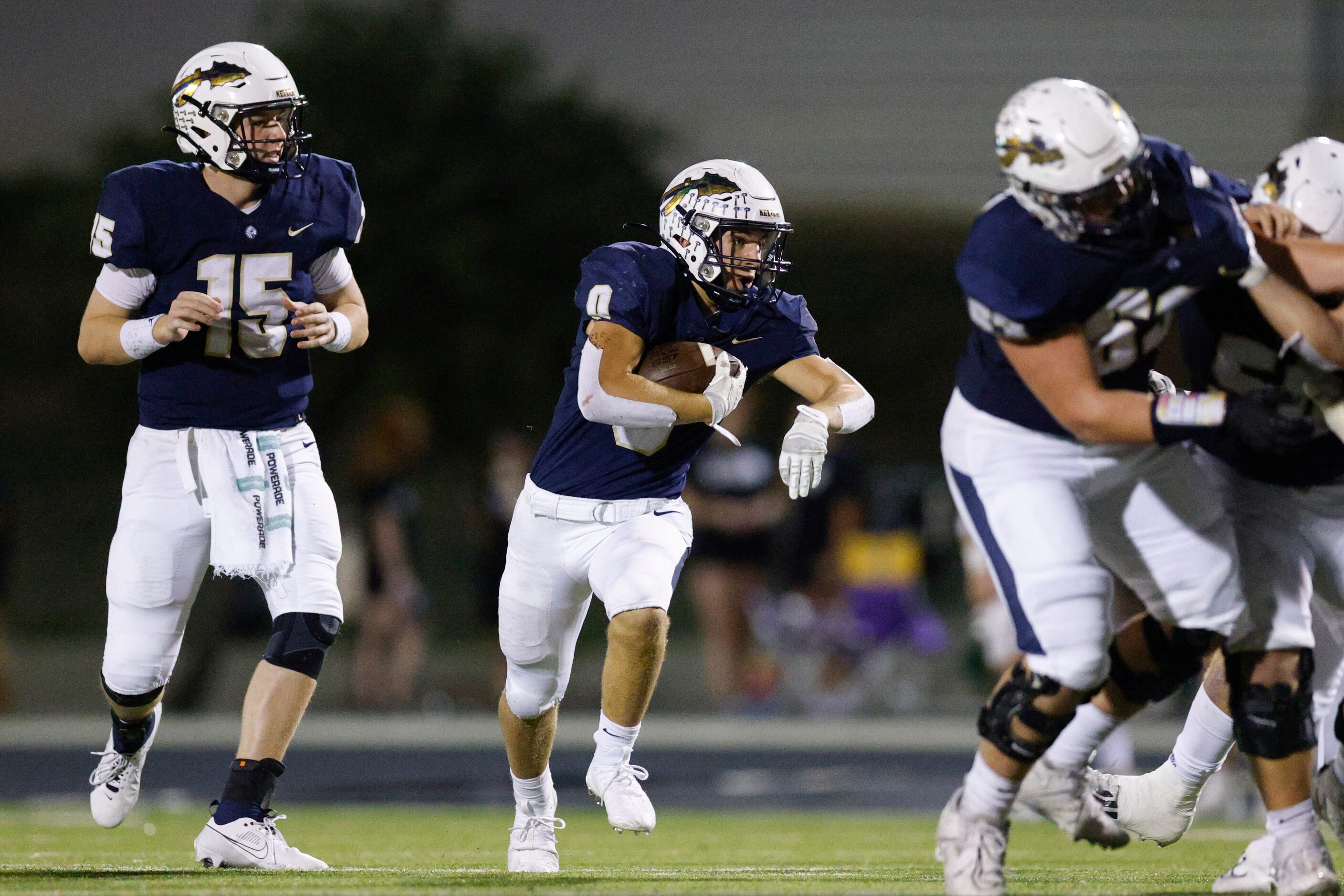 Keller running back Kyle Owens takes the handoff from quarterback Beckham Robinson (15)...