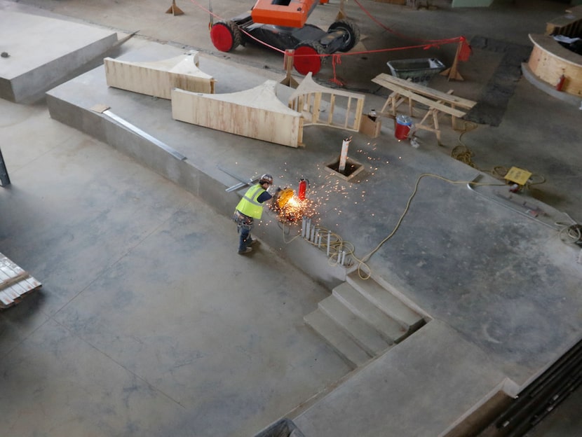 Sparks fly as a worker cuts a metal pipe in the Arena area of Texas Live in Arlington on...