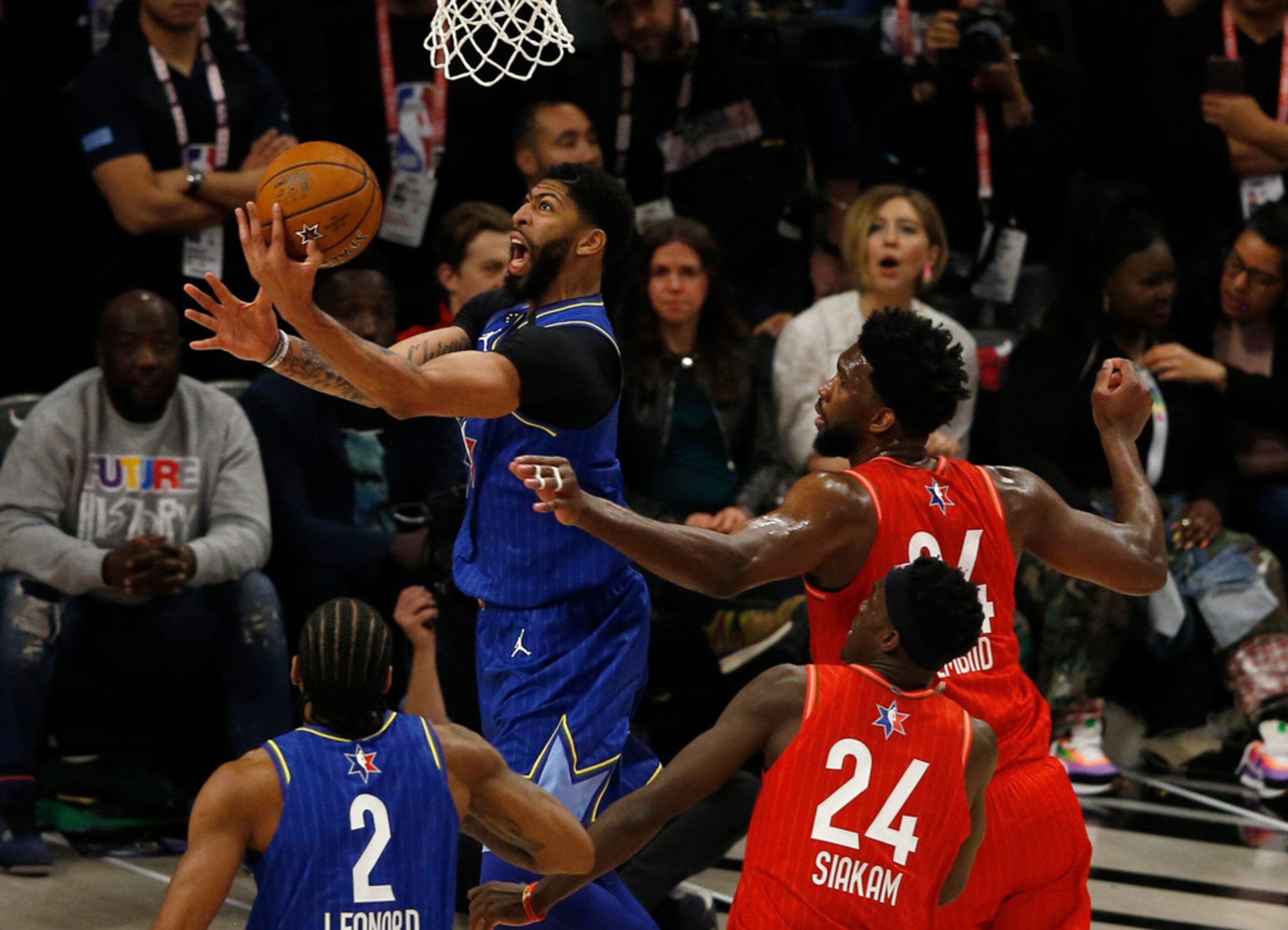 Team LeBron's Anthony Davis (2) attempts a layup in front of Team Giannis' Joel Embiid (24)...