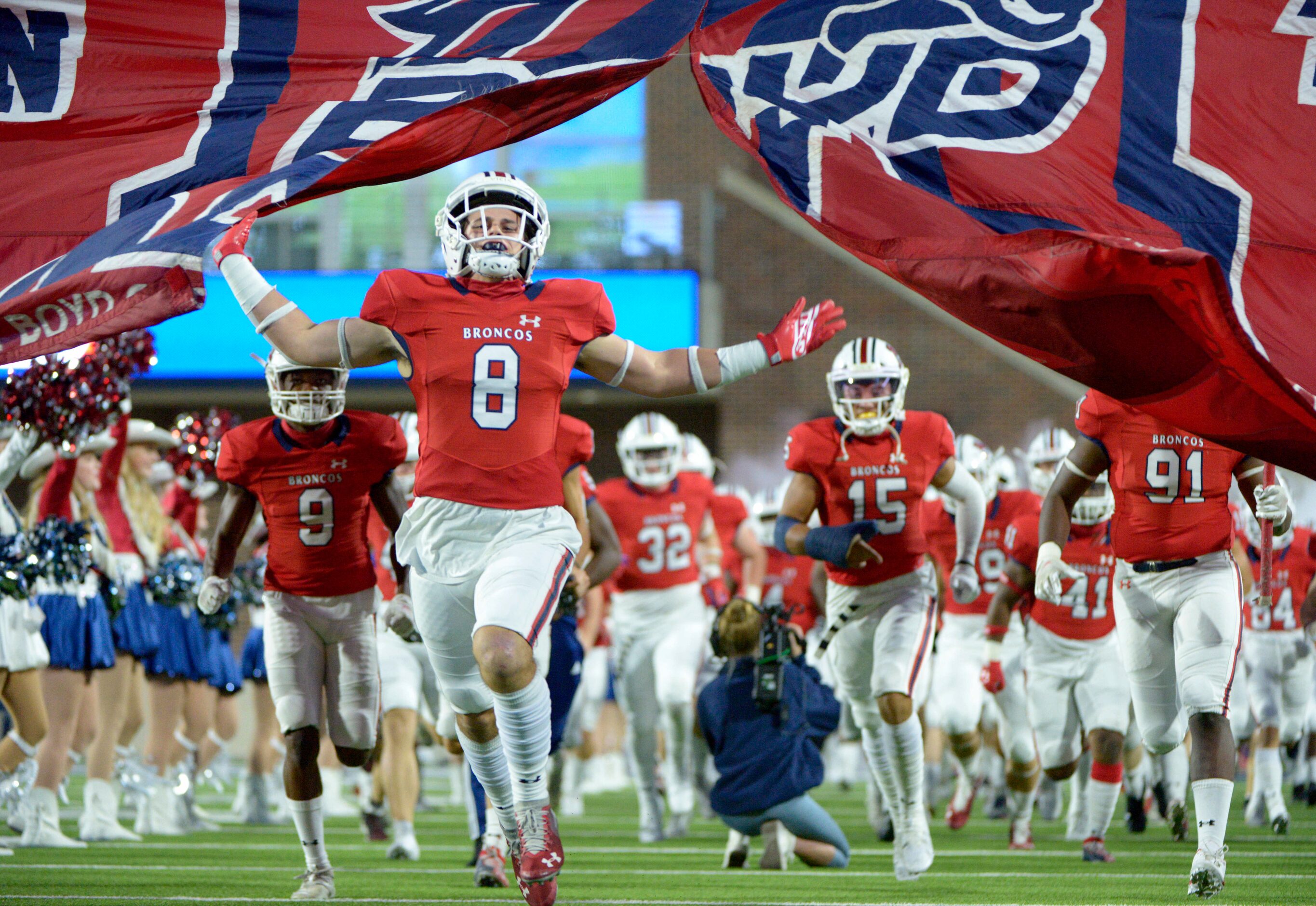 McKinney Boyd players run onto the field before a high school football game between Denton...