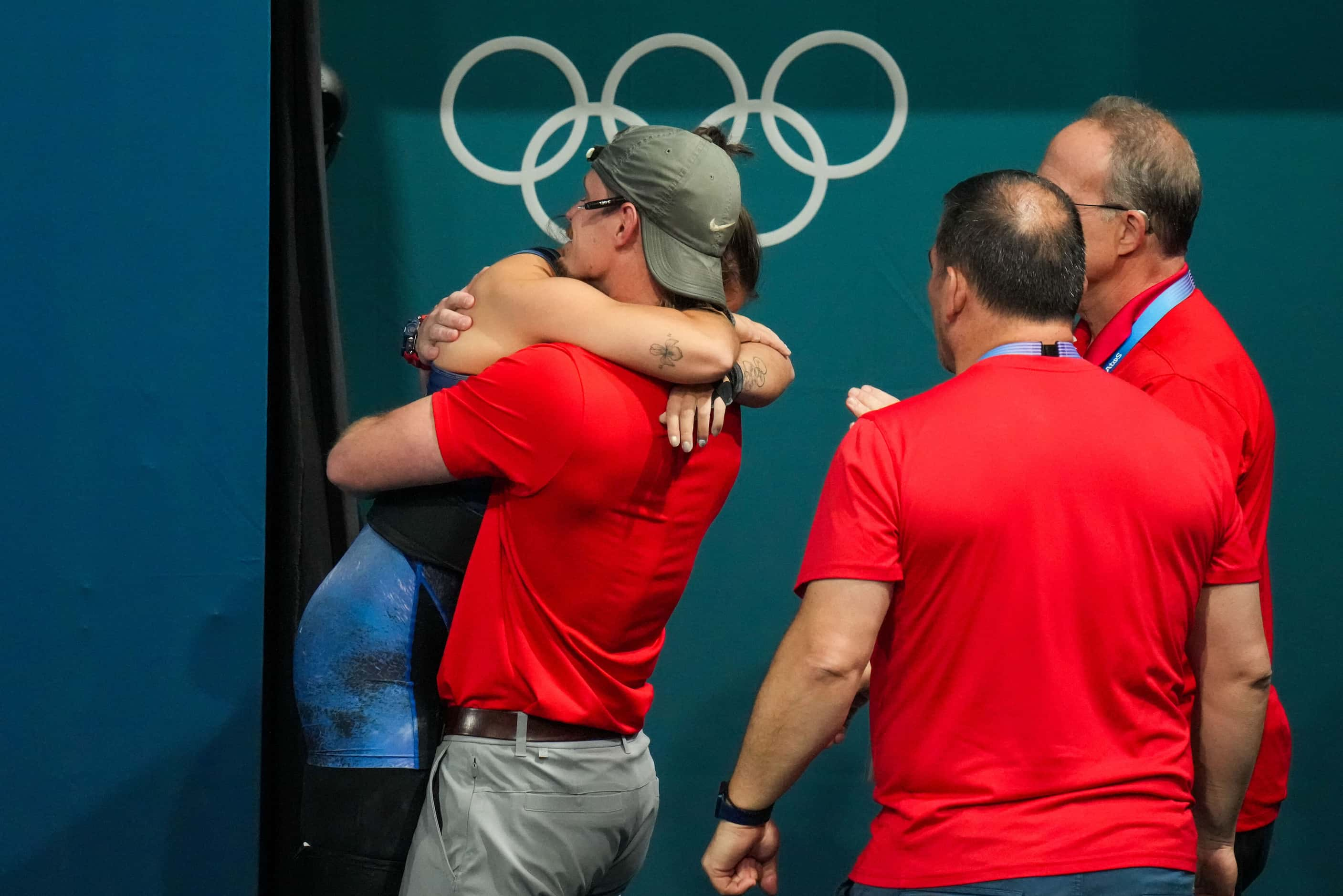 Jourdan Delacruz of the United States hugs coach Spencer Arnold after lifting 111kg in the...