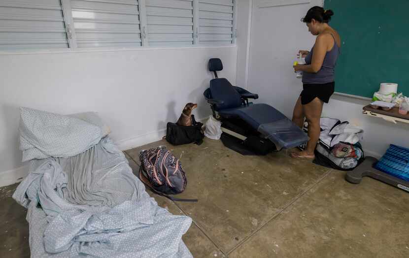 A woman and her dog take refuge in a shelter from Hurricane Fiona in Loiza, Puerto Rico,...
