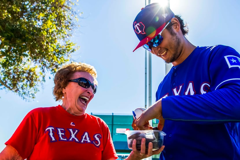 Shirley Kost, also known as "the cookie lady," gives a cookie to Texas Rangers starting...