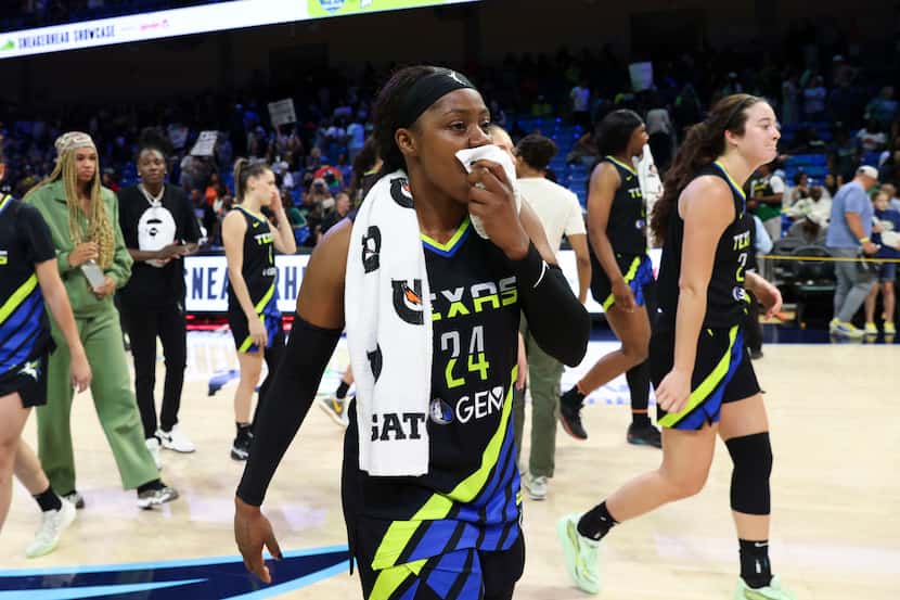 Dallas Wings guard Arike Ogunbowale (center) with her teammates exits the court after...
