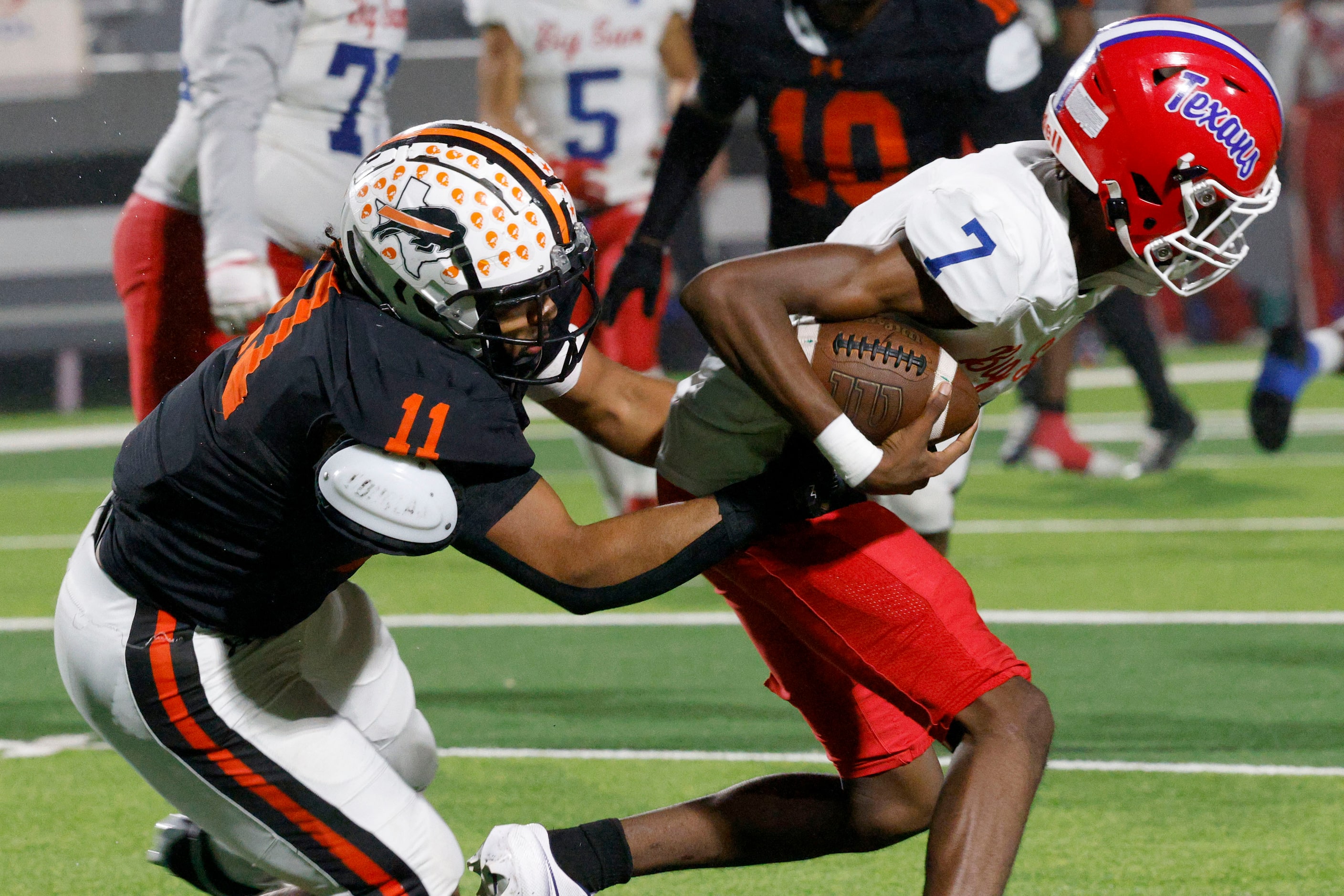 Sam Houston's Ken Jones (7) carries the ball against Haltom's Damien Wayne (11) in the...