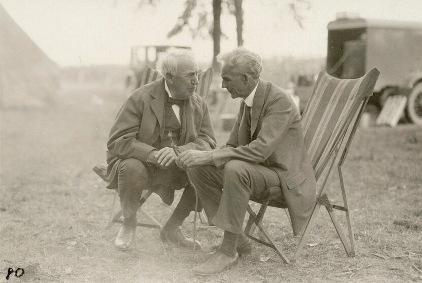 (From left) Thomas Edison and Henry Ford engage in discussion while at a campsite. 