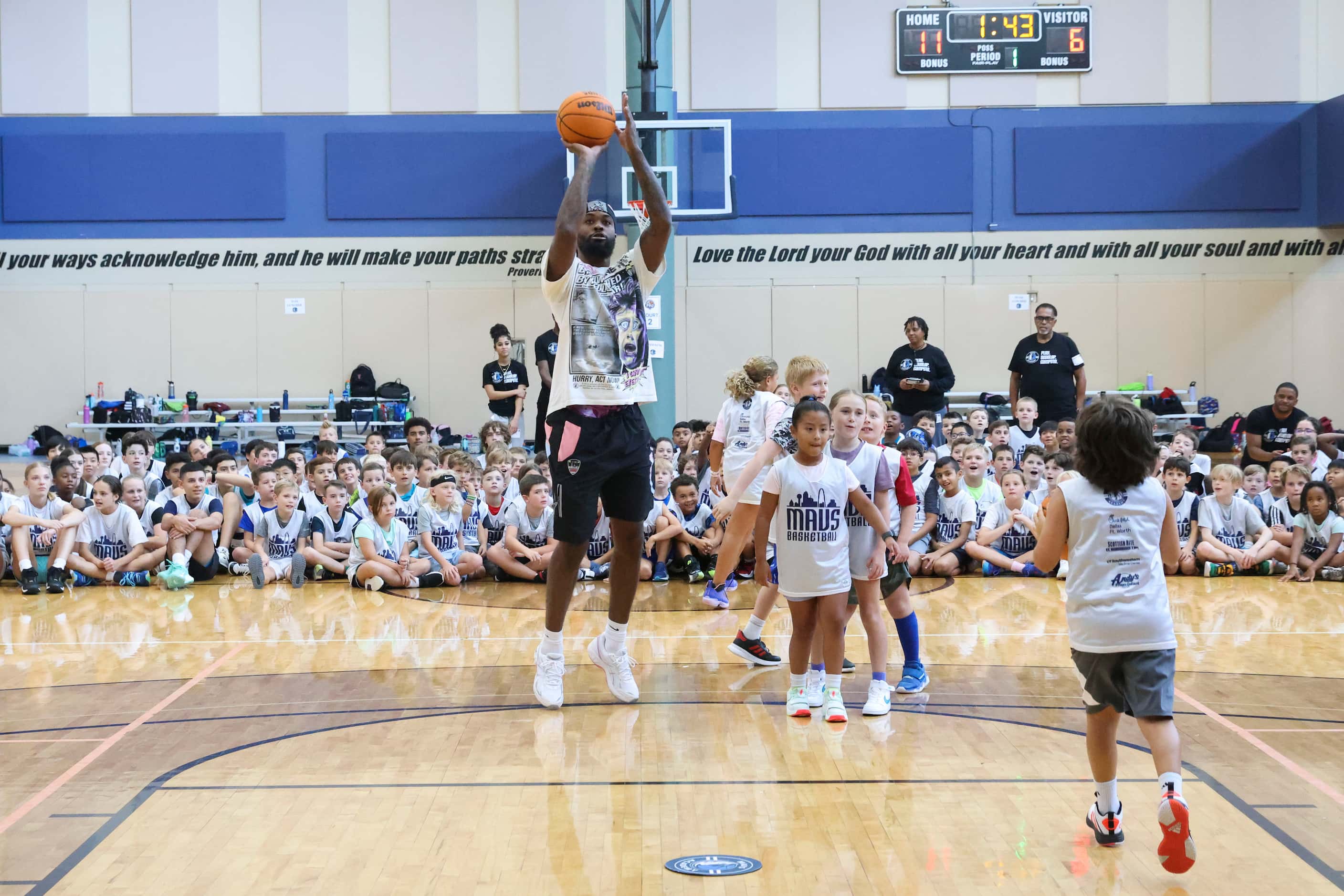 Dallas Mavericks’ Naji Marshall, shoots three-pointers with young basketball campers during...