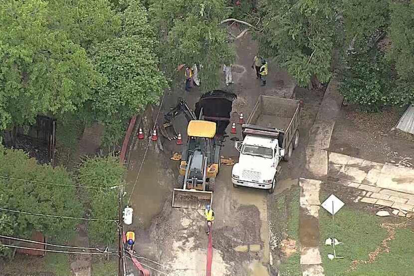  Dallas Water Utilities workers repair a sinkhole in northwest Dallas on Wednesday. (KXAS-TV...