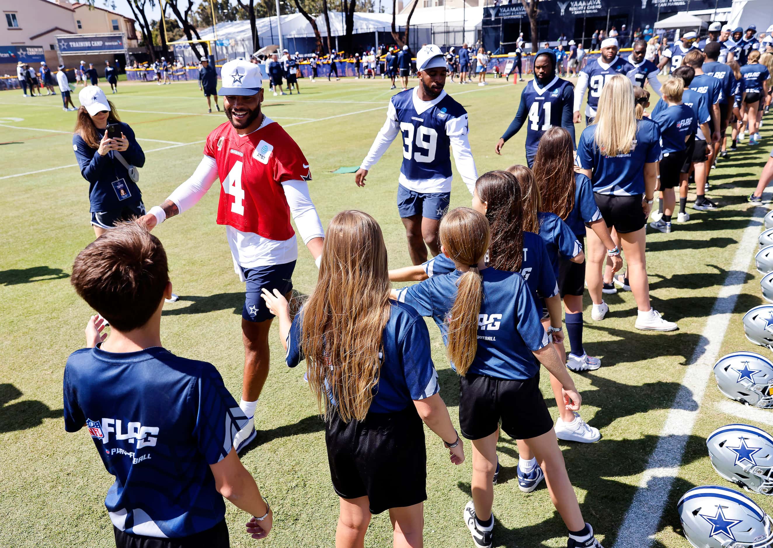 Youth NFL Flag Football players from Ventura County slap hands with Dallas Cowboys players,...