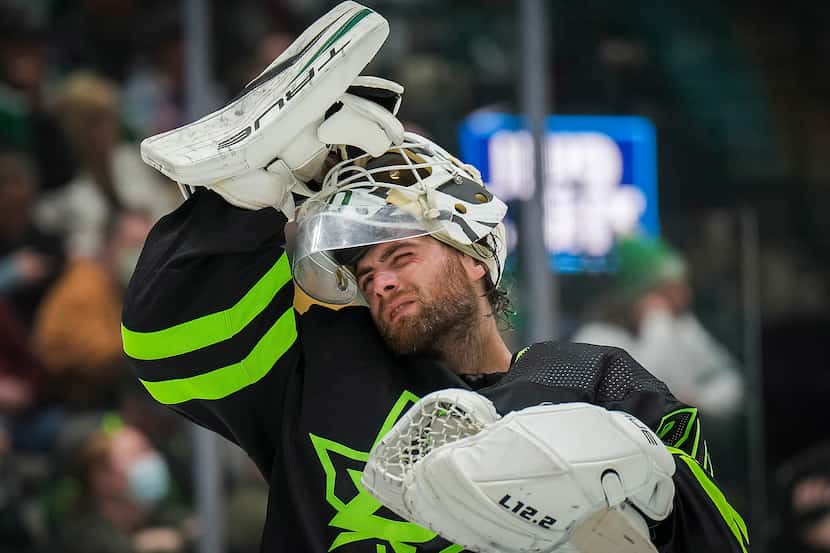 Dallas Stars goaltender Braden Holtby adjusts his mask during the second period of an NHL...