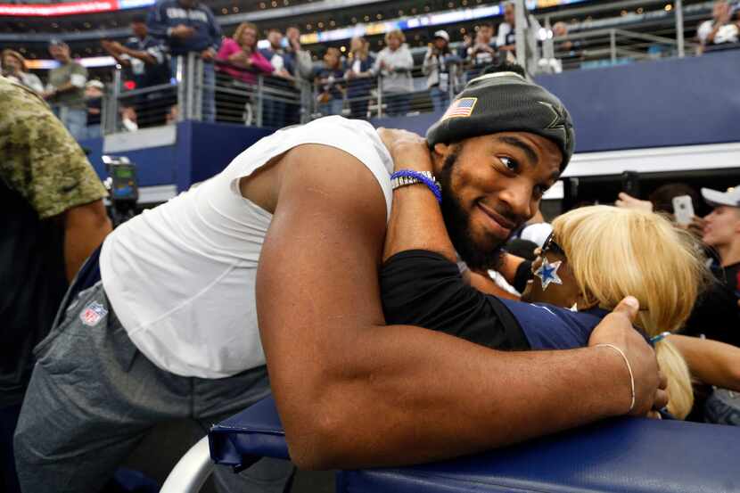Carolyn Price hugs Dallas Cowboys rookie Rico Gathers from the practice squad before a game...