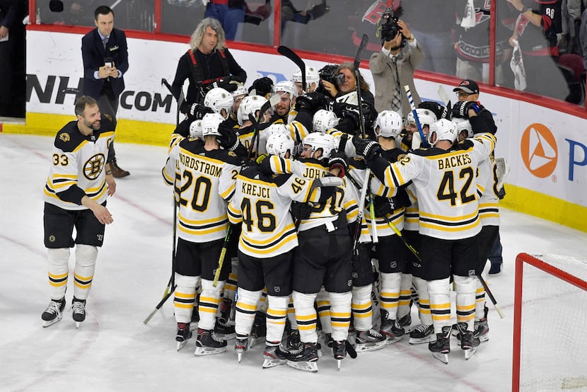 RALEIGH, NORTH CAROLINA - MAY 16: The Boston Bruins celebrate after defeating the Carolina...