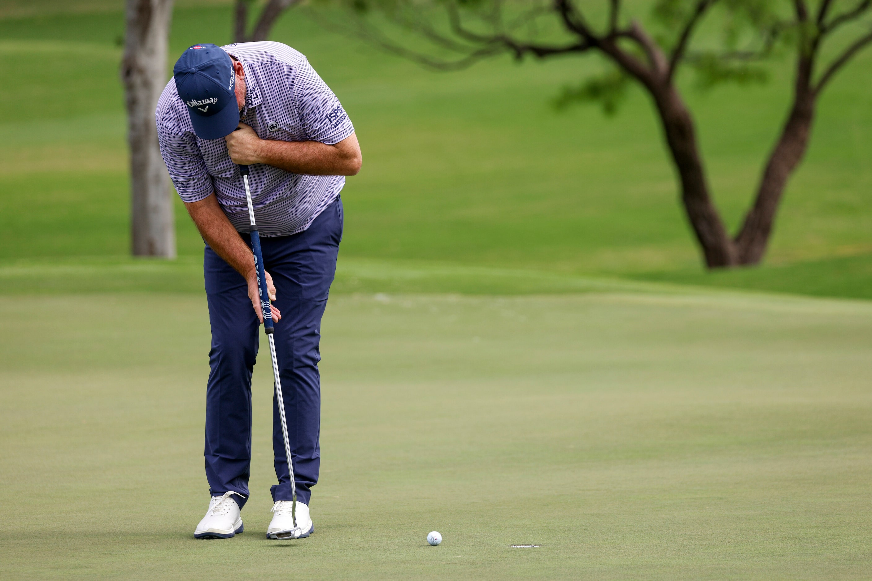 Professional golfer Thomas Bjorn putts for par on the 14th green during the first round of...