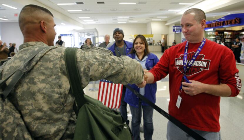 John Knuppe (right) of Fort Worth was one of the volunteers greeting troops arriving for R&R...