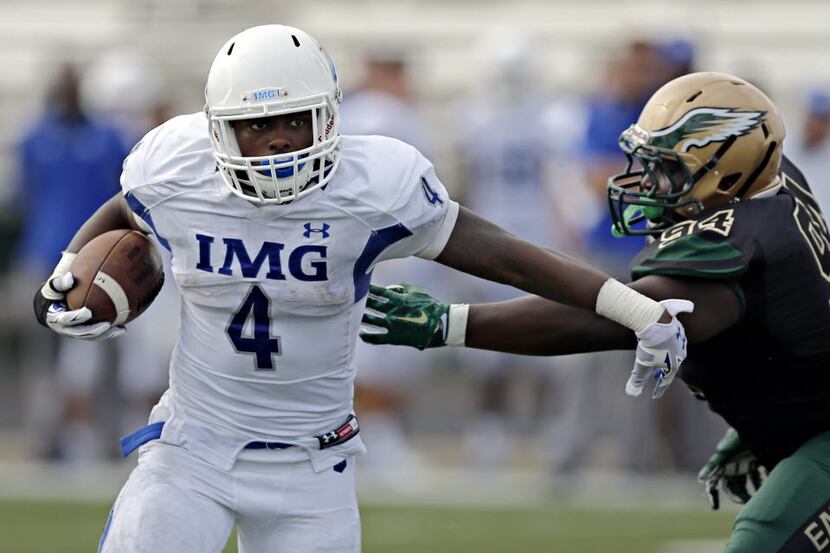 IMG's Tony Jones brushes off a tackle attempt by DeSoto's Curdarence Chambers during the...