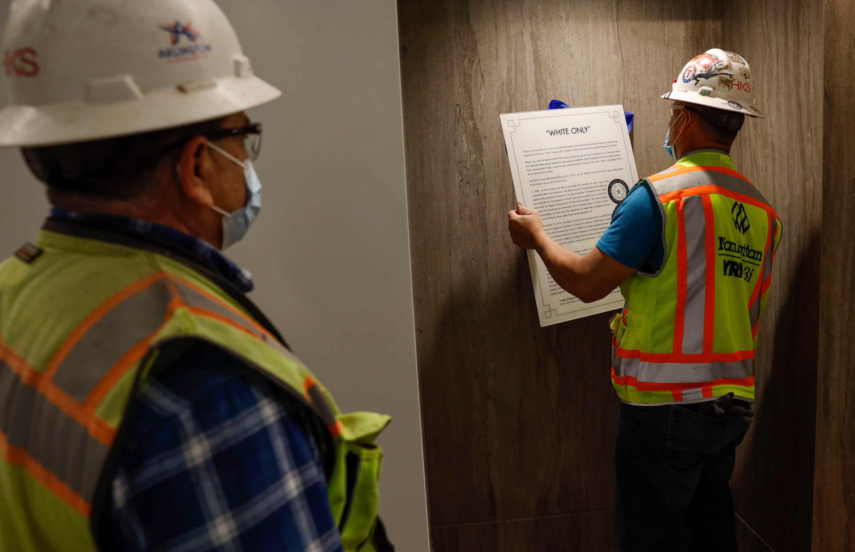 Saul Fuentes removes a “white only” historical informative sign near where the...