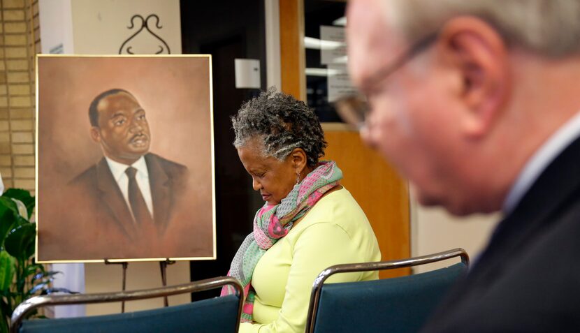 Emma Rodgers bows her head in prayer at the start of a ceremony to commemorate the 50th...