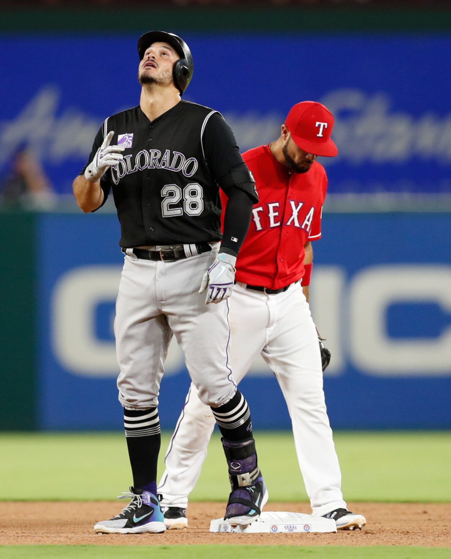 Colorado Rockies' Nolan Arenado (28) celebrates his double in front of Texas Rangers second...