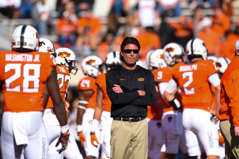 Oklahoma St head coach Mike Gundy watches warm-ups prior to a NCAA college football game...