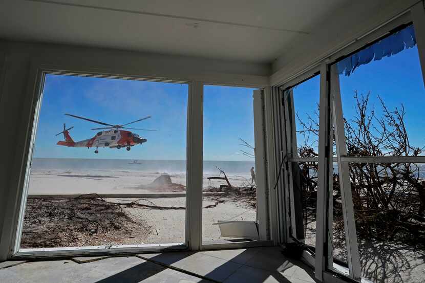 Un helicóptero de la Guardia Costera de Estados Unidos visto desde el interiro de una casa...