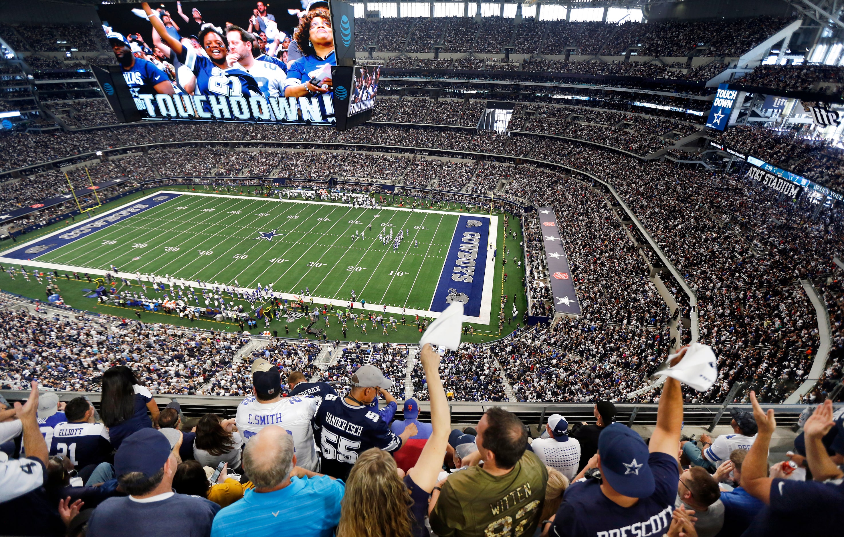 Fans are displayed on the giant overhead video screen as Dallas Cowboys fans cheer tight end...