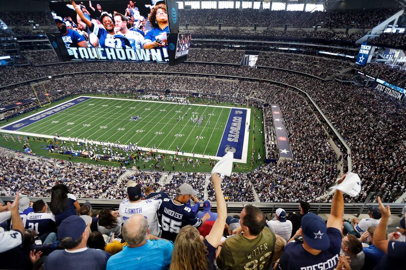 Fans are displayed on the giant overhead video screen as Dallas Cowboys fans cheer tight end...