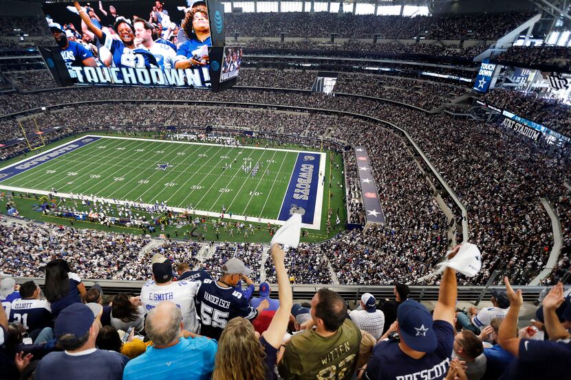 Fans are displayed on the giant overhead video screen as Dallas Cowboys fans cheer tight end...