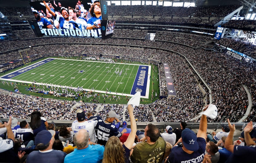 Fans are displayed on the giant overhead video screen as Dallas Cowboys fans cheer tight end...