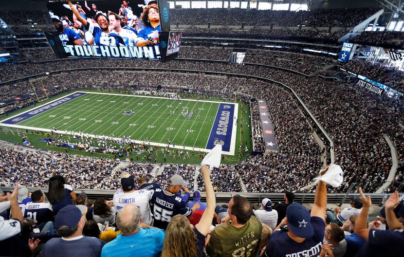 Fans are displayed on the giant overhead video screen as Dallas Cowboys fans cheer tight end...