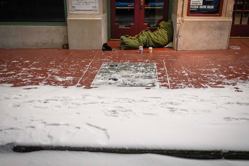 With temperatures already falling into the single digits, a homeless person sleeps in the...