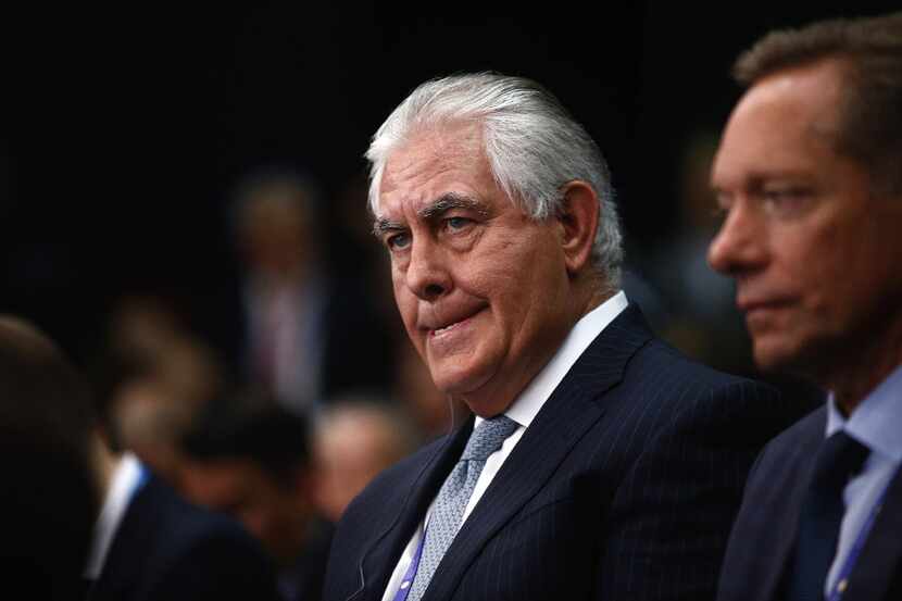 Rex Tillerson (left), chief executive officer of Exxon Mobile Corp., listens on the opening...