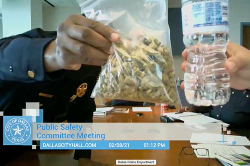 A bag of marijuana is held up during a public safety committee meeting held virtually in...