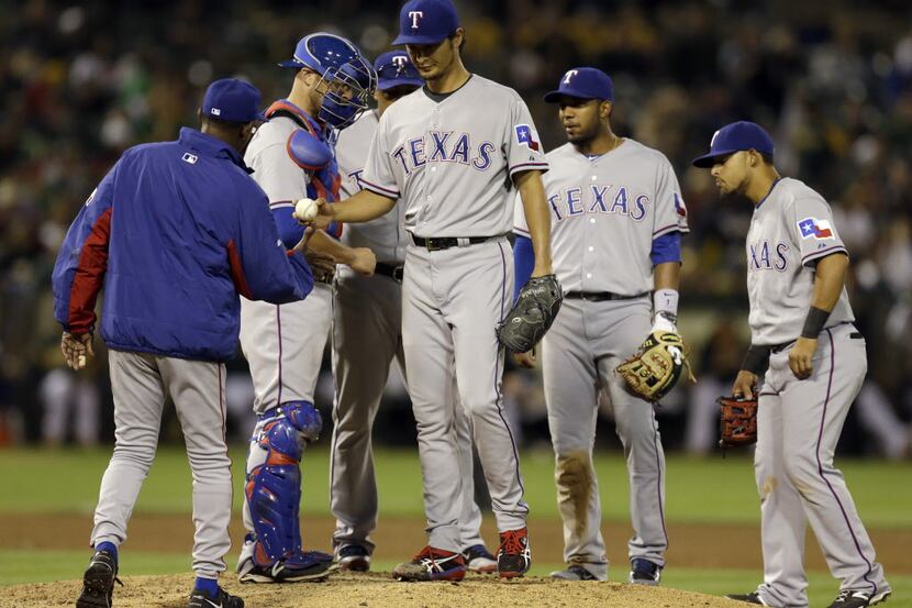 Texas Rangers' Yu Darvish hands the ball to manager Ron Washington as he is removed from the...