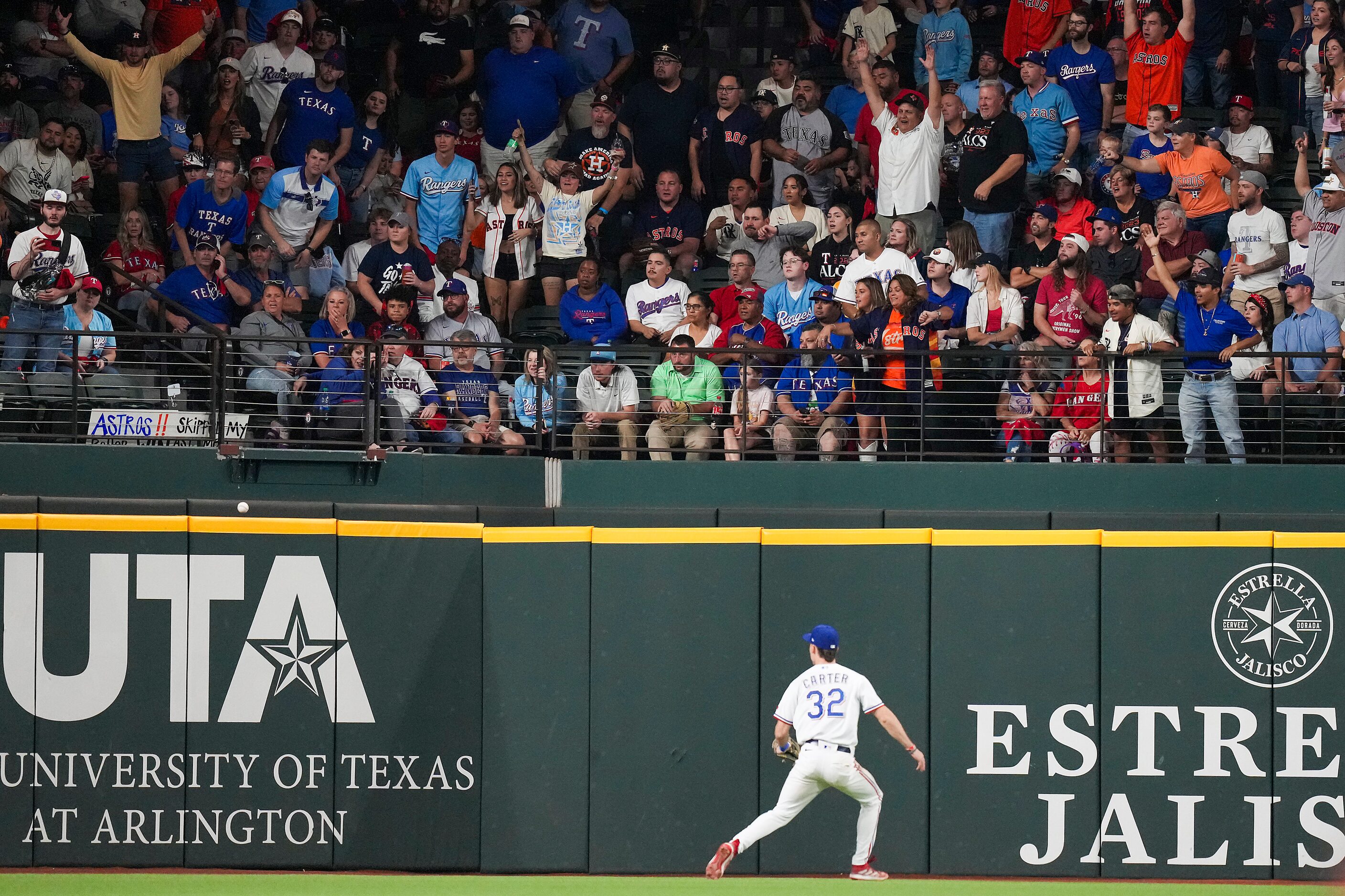 Texas Rangers left fielder Evan Carter chases a double by Houston Astros second baseman Jose...