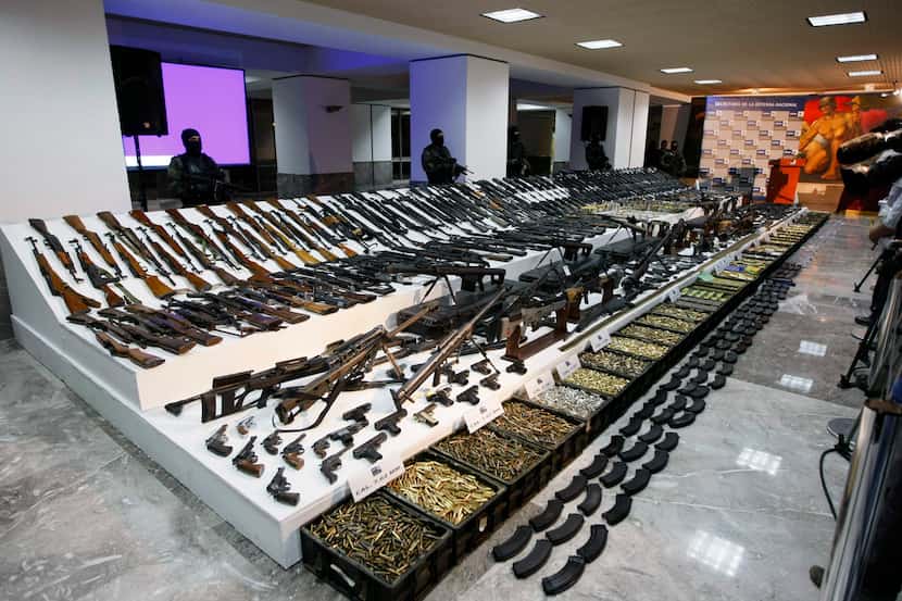 Soldiers stand guard during a 2008 presentation of weapons seized during an operation...