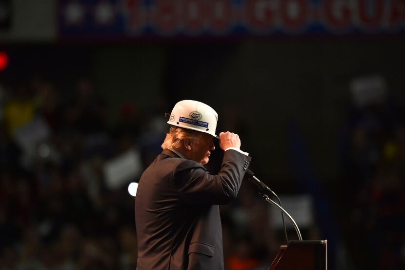 Donald Trump wears a coal miner's protective hat while addressing his supporters during a...