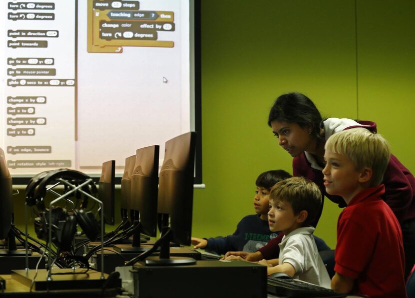 
UTD student Neelima Velagapudi assists Mitchell Gregg (center) Gael Aguirre and Casey...