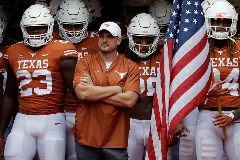 Texas head coach Tom Herman, with arms crossed, waits with his team to take the field for an...