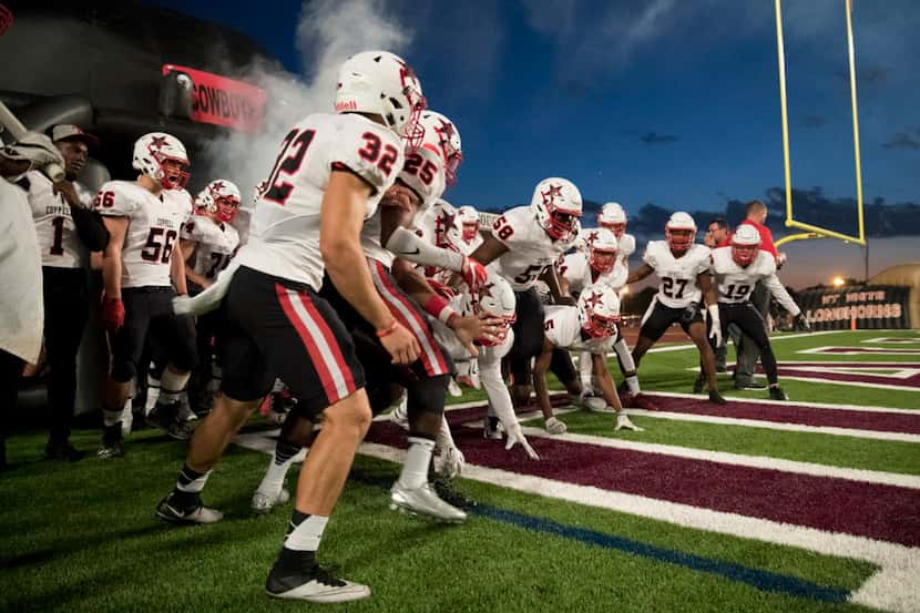 Coppell Cowboys players running out the inflatable tunnel during the high school football...