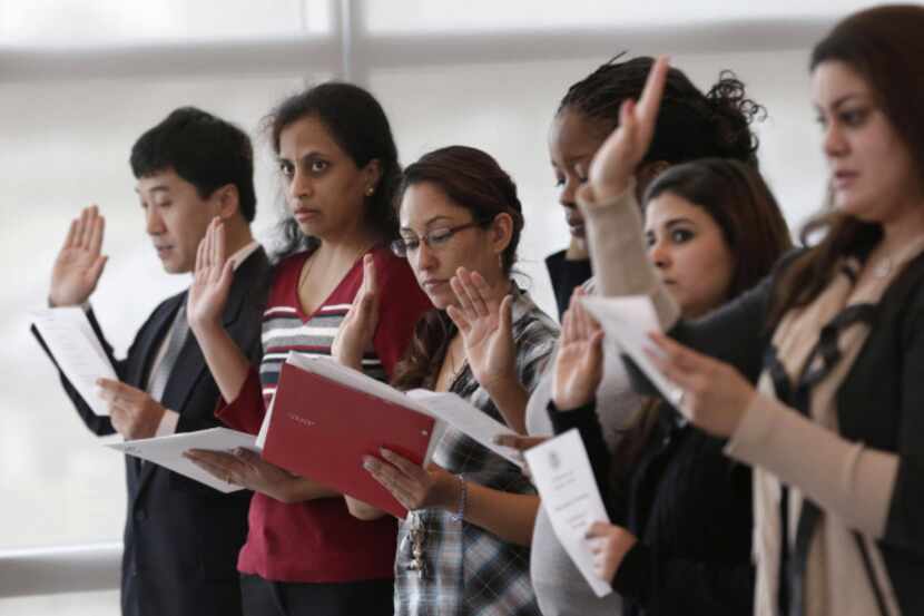 Immigrants take the U.S. oath of citizenship during naturalization ceremony on Monday in...