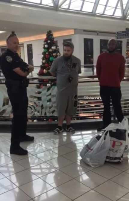 Brandon Kibart (center) and Ro Lockett (right) talk with a Frisco police officer after they...