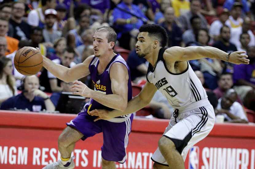 Los Angeles Lakers' Alex Caruso drives around Sacramento Kings' Naz Mitrou-Long during the...