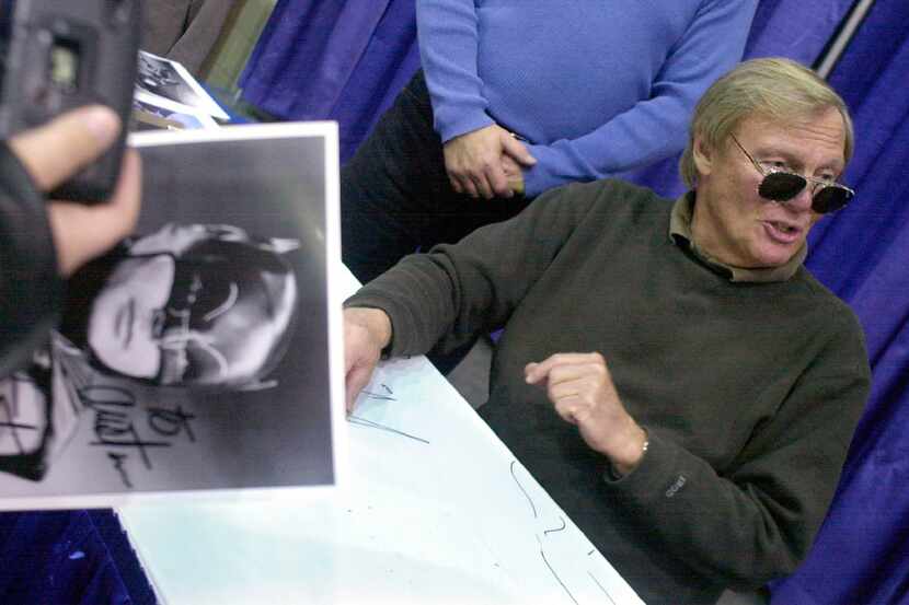 Aa fan holds a signed photograph of actor Adam West, right, during the 50th Autorama in...