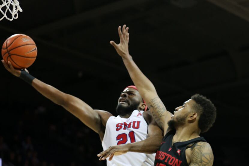 Southern Methodist Mustangs guard Ben Emelogu II (21) lays up a shot against Houston Cougars...