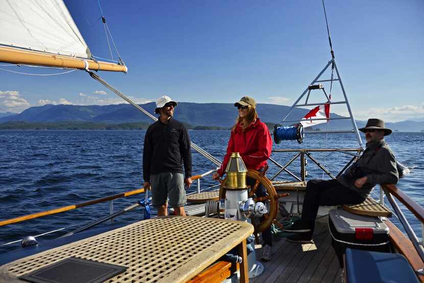 One of the guests steers Passing Cloud through British Columbia's coastal waters. 