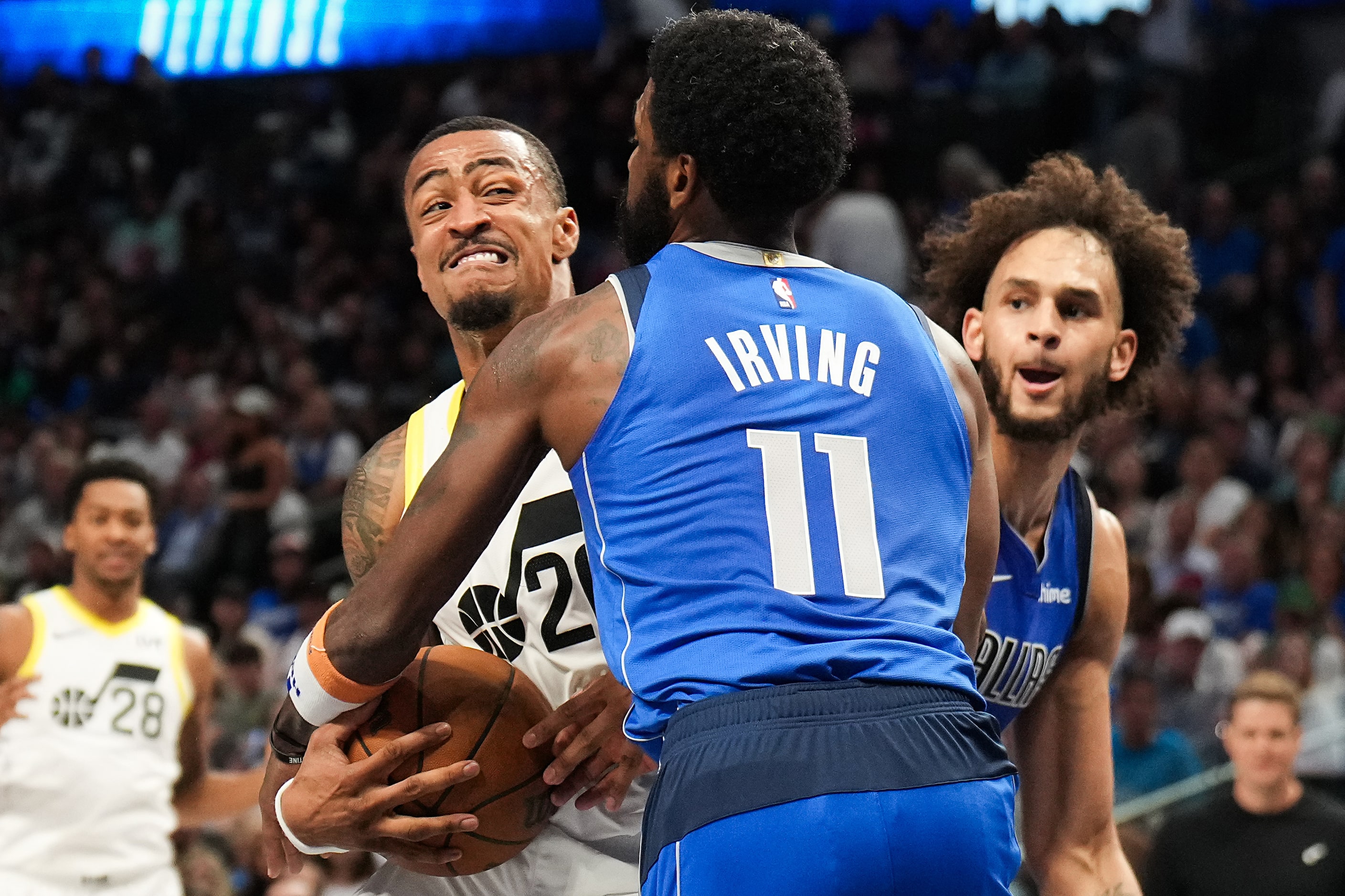 Dallas Mavericks guard Kyrie Irving (11) defends a drive by Utah Jazz forward John Collins...