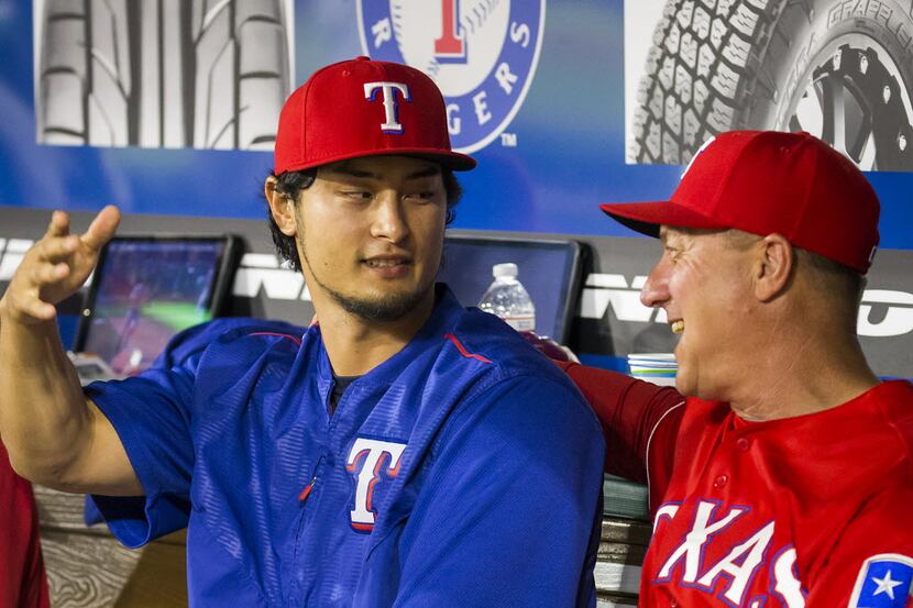 Texas Rangers starting pitcher Yu Darvish chats with manager Jeff Banister in the dugout...