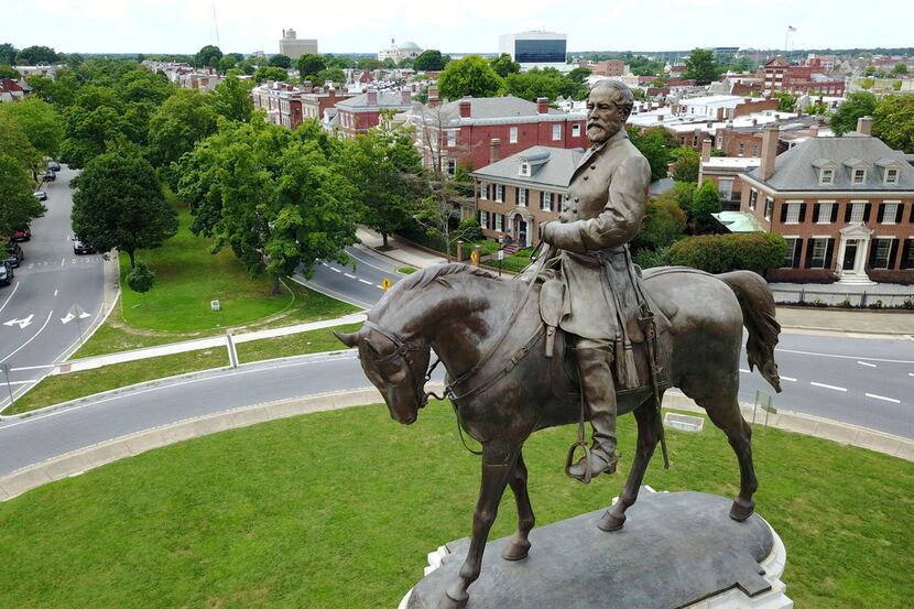 A statue of Confederate Gen. Robert E. Lee stands in the middle of a traffic circle on...