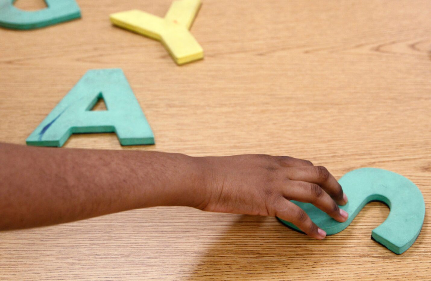 A student in Carolyn Dreyer's Activities of Daily Living class picks up a foam letter at Ann...